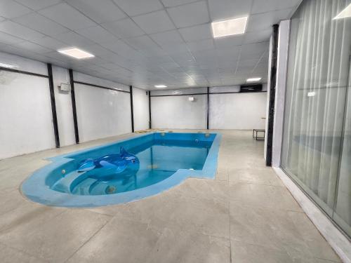 a large blue swimming pool in a room at Al manama villa 2 in á¸¨aÅŸat al BidÄ«yah