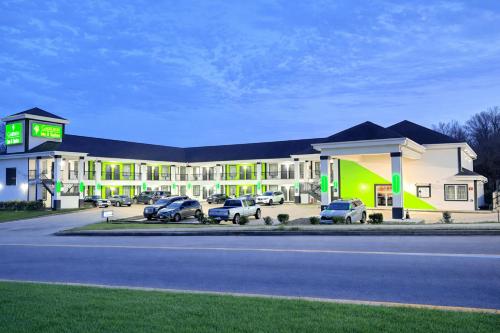 a hotel with cars parked in a parking lot at Garden Inn & Suites Little Rock in Little Rock