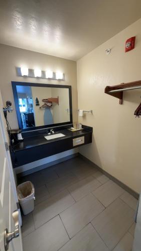 a bathroom with a sink and a large mirror at Garden Inn & Suites Little Rock in Little Rock