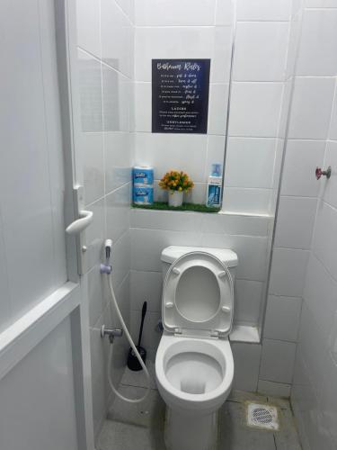 a bathroom with a toilet with a sign on the wall at Mo Homes studio in Mombasa
