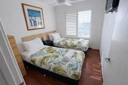 two beds in a small room with a window at Scarborough Beach Front Resort - Shell Thirteen in Perth