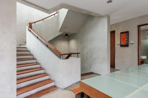 a staircase in a house with a glass table at Urbanview Hotel The Lodge Karawaci in Tangerang