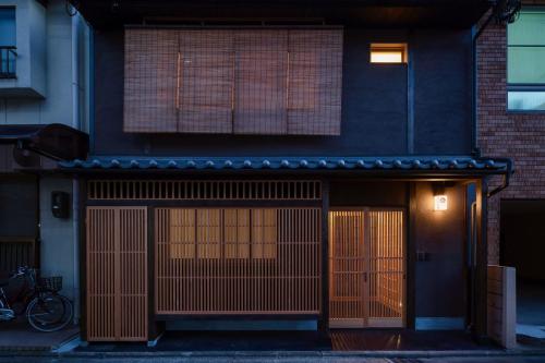a building with two garage doors in front of it at Ayaginu Machiya House in Kyoto