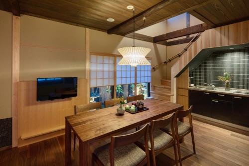 a dining room with a wooden table and chairs at Ayaginu Machiya House in Kyoto