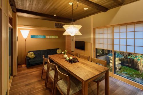 a dining room with a table and a couch at Ayaginu Machiya House in Kyoto
