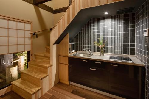 a kitchen with a sink and a stairway at Ayaginu Machiya House in Kyoto