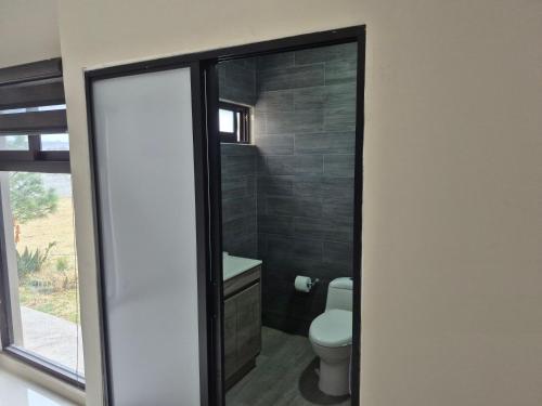 a bathroom with a toilet and a mirror at Finca Sierra Madre in Durango