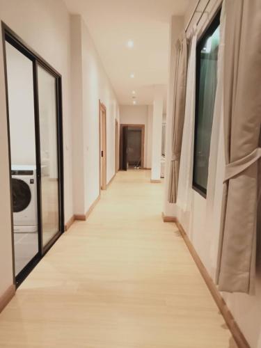 a corridor of a house with white walls and windows at Patra Phuket Private Residence in Ban Nong Chaeng