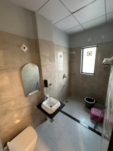 a bathroom with a sink and a toilet and a mirror at Royal kesari in Jhunjhunūn