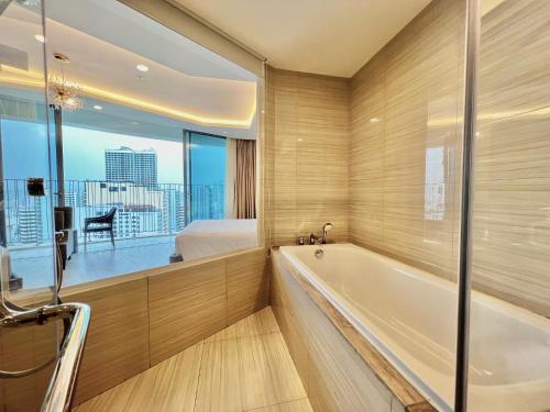 a bathroom with a bath tub and a bedroom at Panorama Ocean View Luxury Apartment Nha Trang in Nha Trang