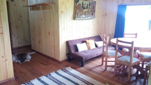 a living room with a purple couch and a table at Cabaña Pucon a Huife in Pichare
