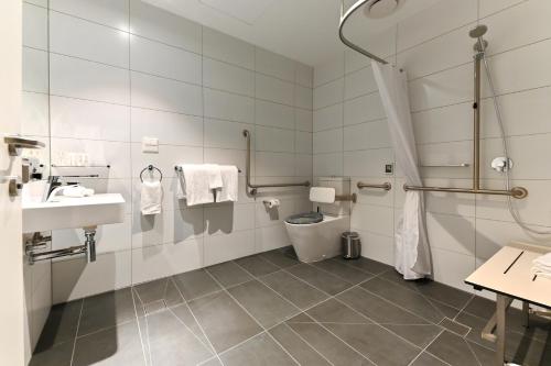 a bathroom with a toilet and a sink at Nesuto Curtin Perth Hotel in Perth