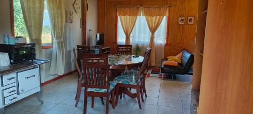 a kitchen with a dining room table and chairs at Cabaña La Ondina in Melipeuco