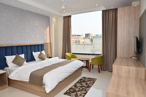 a hotel room with a bed and a desk and a window at Hotel The Sabhyansh in Khātu