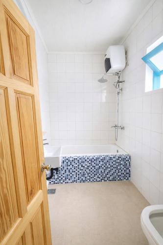 a bathroom with a bath tub and a sink at Tomato Villa & Restaurant in Da Lat