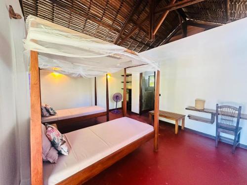 a bedroom with a bunk bed in a room at Bungalow du Lagon in Ambaro