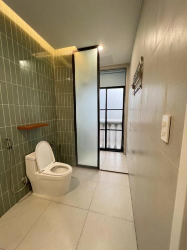 a bathroom with a toilet and a door with a window at Biệt thự Hồ Tràm B SH42 in Xuyên Mộc