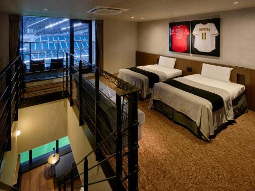 a hotel room with two beds and a balcony at tower eleven hotel in Kitahiroshima
