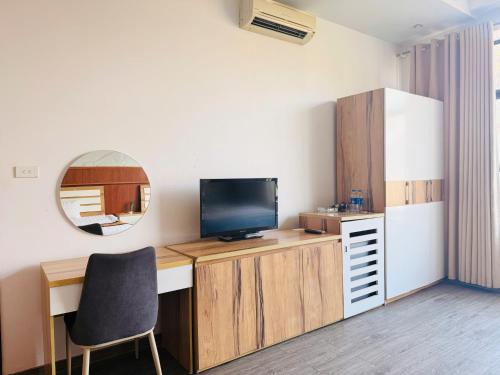 a room with a desk with a television and a mirror at Hoa Viên Hotel in Hòa Ðình