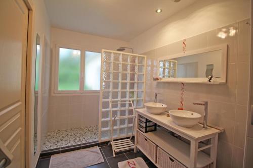a bathroom with two sinks and a mirror at Le pin parasol in Arnac-la-Poste
