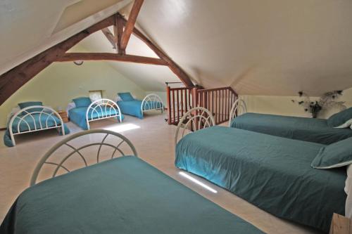 a room with two beds and chairs in a attic at Le monteil in Arnac-la-Poste