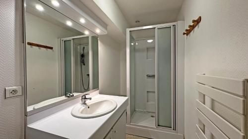 a white bathroom with a sink and a shower at Le gîte communal in Dompierre-les-Églises