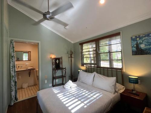 a bedroom with a white bed and a window at Grey Gum Lodge in Nimbin