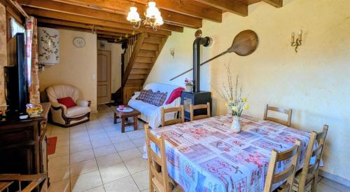 a dining room with a table and a couch at La rivaille in Lussac-les-Églises