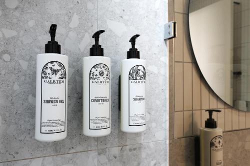 Eine Gruppe von vier Shampooflaschen an einer Badezimmerwand in der Unterkunft 호텔 더블랙 in Hwangsan-do