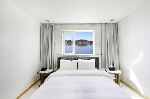 ein Schlafzimmer mit einem großen Bett und einem Fenster in der Unterkunft 호텔 더블랙 in Hwangsan-do