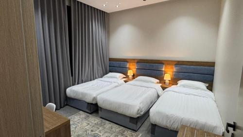 a hotel room with three beds in a room at شقق العامر in Jeddah