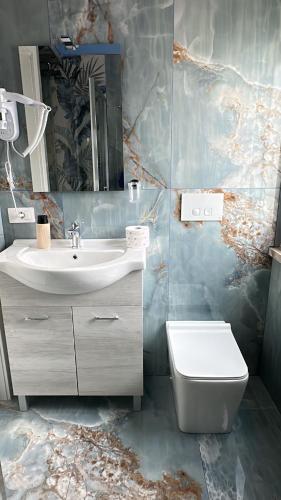 a bathroom with a sink and a toilet and a mirror at Tower casa vacanze 2 in Anzio