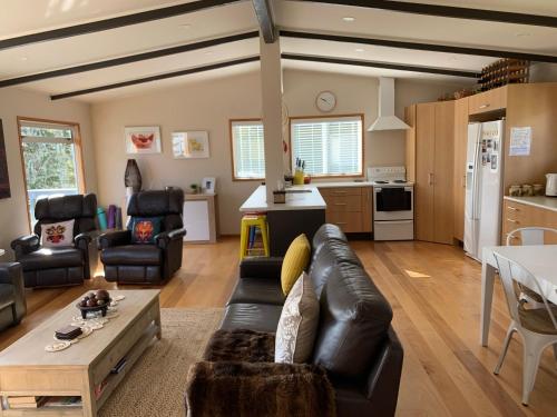 a living room with a couch and a table at Lake Views, Ani Miria Place, Te Rangiita, Turangi in Turangi