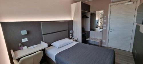 a bedroom with a bed and a desk and a bathroom at Art Hotel Udine in Udine