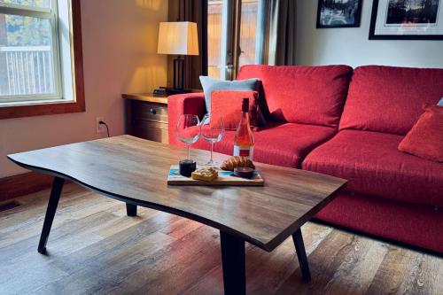 a living room with a red couch and a wooden coffee table at Spacious, Pet Friendly, Townhouse Hot Tub Perfect for Families! in Canmore