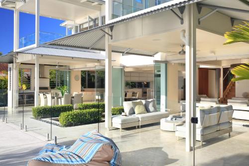 a house with glass doors and white furniture at The Peninsula Secret - spacious waterfront & heated Spa in Noosaville