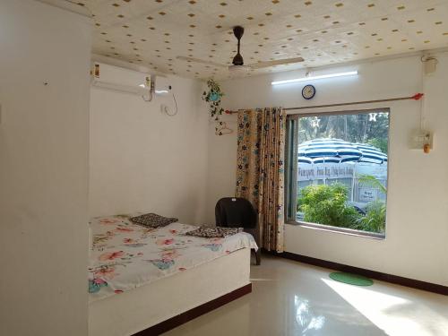 a small bedroom with a bed and a window at Holiday Homestay Beach Rooms Deep Diving & Light House & Watersports Tarkarli in Bhogwe