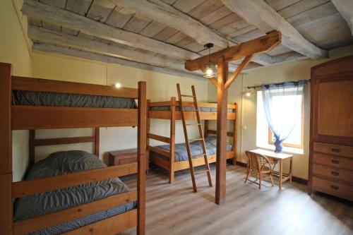 a bedroom with two bunk beds and a desk at Lou peyrahout in Javerdat