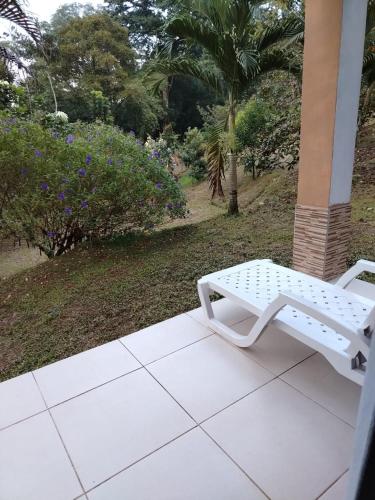 a white bench sitting on top of a porch at Finca Kapok tree in Miramar