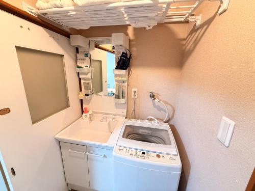 a washing machine in a bathroom with a sink at SUN PALACE Fussa 阳光家园 in Fussa