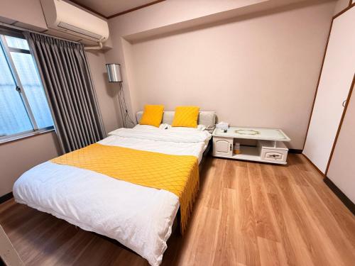 a bedroom with a large bed with yellow pillows at SUN PALACE Fussa 阳光家园 in Fussa
