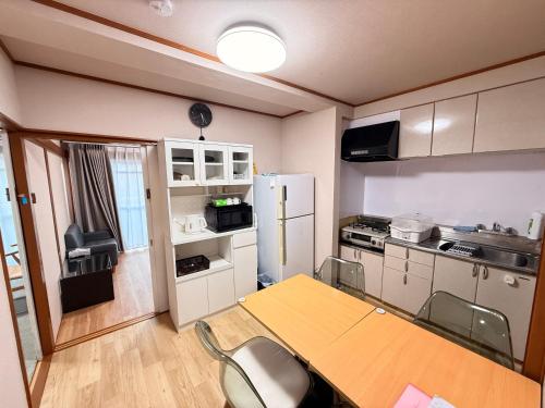 a small kitchen with a table and a refrigerator at SUN PALACE Fussa 阳光家园 in Fussa