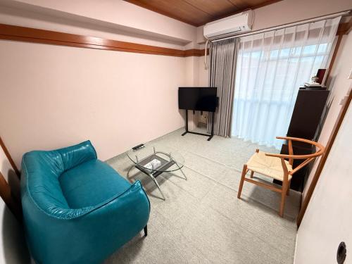 a living room with a blue couch and a television at SUN PALACE Fussa 阳光家园 in Fussa