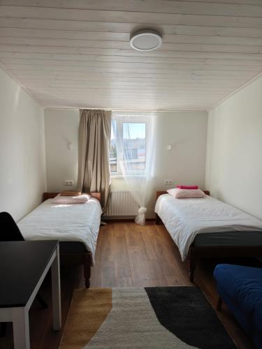 zwei Betten in einem Zimmer mit Fenster in der Unterkunft Tamme in Otepää