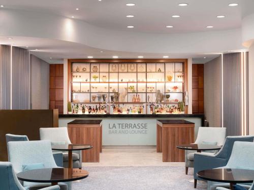 a lobby with tables and chairs and a display case at Sofitel London Gatwick in Horley
