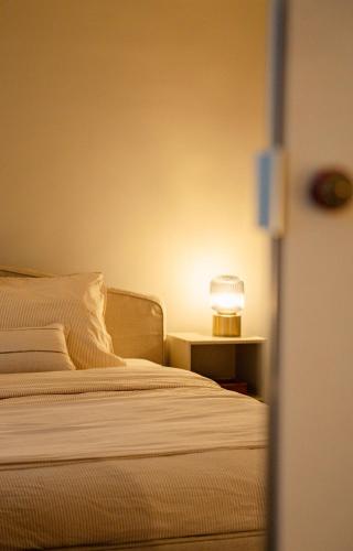 a bedroom with a bed and a lamp on a night stand at Naest - Authentic Escapes Old Town Villa Nijmegen in Nijmegen