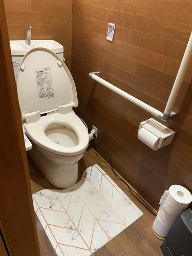 a bathroom with a toilet with a sign on the floor at 昭和神ヶ谷ハウス in Hamamatsu
