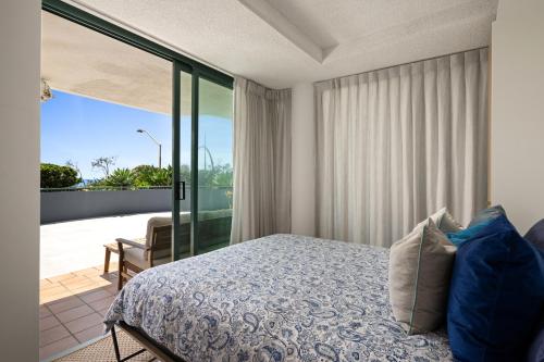 a bedroom with a bed and a balcony at Classic Coastal Escape - 1 Bedroom Ocean Views in Maroochydore