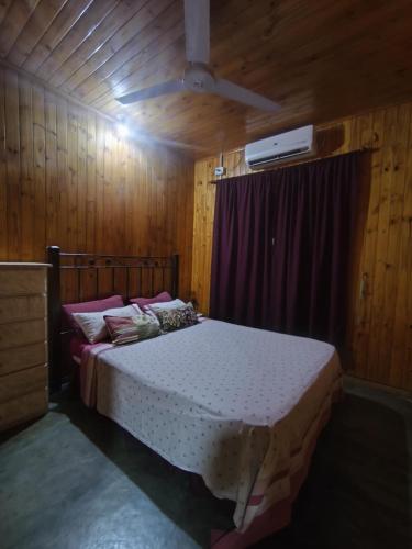 a bedroom with a bed in a wooden room at Silvia Cabaña Confort in Puerto Iguazú