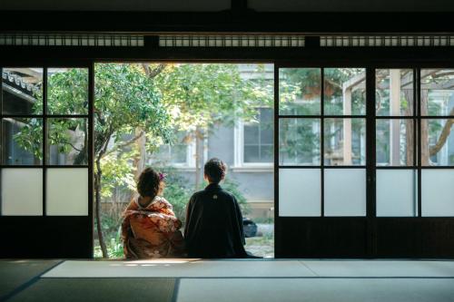 a man and woman sitting in front of a window at Shirafuji in Suzaka